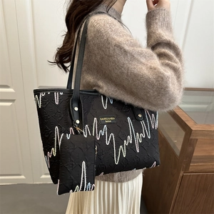 Fashionable black embroidered tote bag with textured finish and matching coin purse