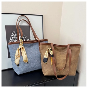 Detail of leather trim and printed silk scarf on canvas tote bags in blue and brown