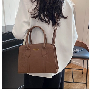 Close-up of the dark brown faux crocodile leather tote bag with gold lettering details