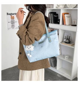 Dettaglio borsa shopper azzurra con stampa a stelle e ciondolo a forma di nuvola