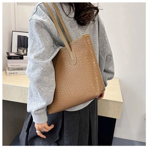 Brown woven texture tote bag worn on shoulder for stylish daily commuting and office use