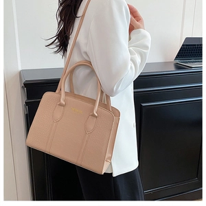 Detail of beige crocodile pattern leather boston bag with gold embossed logo text