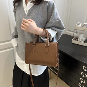Brown vertical striped embossed tote bag with round handles and detachable shoulder strap