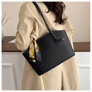 Detail of black tote bag featuring white contrast stitching and decorative silk scarf