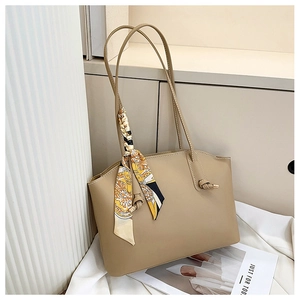 Close-up of a beige tote bag with decorative floral scarf and premium stitching details