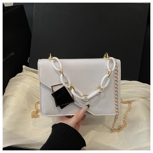 Detail of cream leather crossbody bag with chunky acrylic chain and gold hardware