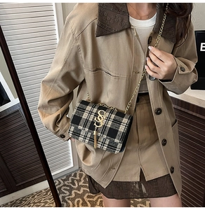 Détail du sac bandoulière en tweed avec motif noir et blanc et chaîne dorée