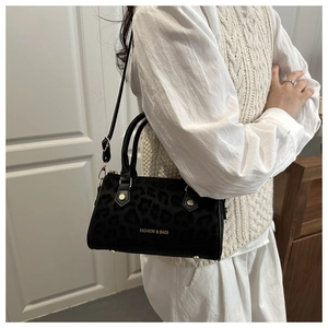 Détails du motif léopard noir et de la quincaillerie dorée du sac à bandoulière
