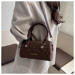 Détail d'un sac cylindre léopard marron avec texte doré et texture en daim doux