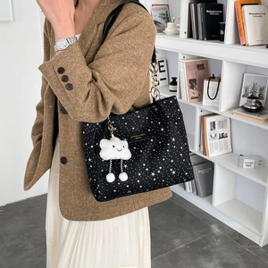 Black star pattern tote bag with gold chain strap and cloud charm shown on model
