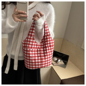 Detail of red and white checkered canvas tote bag with functional front pocket