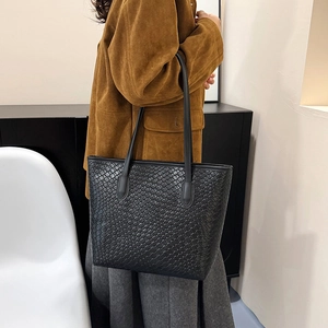 Classic black woven tote bag with large capacity, shown on model for stylish daily use