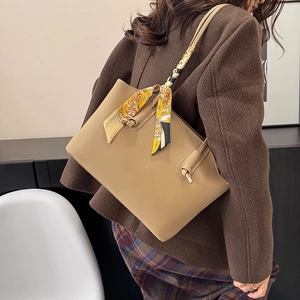 Khaki minimalist tote bag with decorative silk scarf on shoulder strap for urban commute