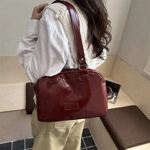 Sac Boston vintage en cuir brillant bordeaux avec logo rectangulaire et bandoulière