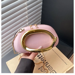 Detail der rosa Lacklederhandtasche mit großem Goldringgriff und Metallreißverschluss
