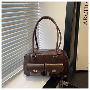 Detail of dark brown vintage handbag with dual exterior pockets and golden twist locks