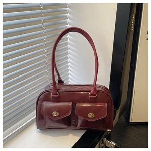 Close-up of retro burgundy pillow bag featuring glossy finish and dual front pockets