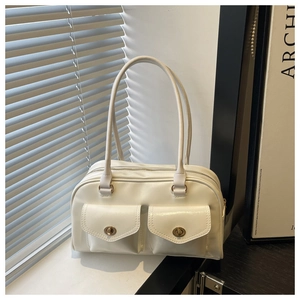 Close-up of beige vintage shoulder bag with dual flap pockets and metal twist-lock hardware