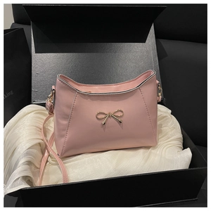Borsa in pelle rosa pallido con fibbia a fiocco dorata in una scatola regalo di lusso