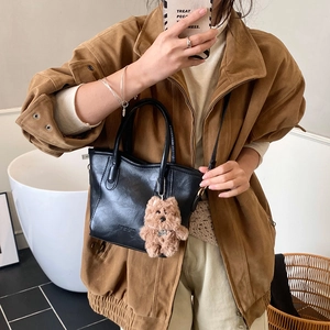 Elegante bolso tipo cubo de cuero sintético negro con un oso de peluche colgado