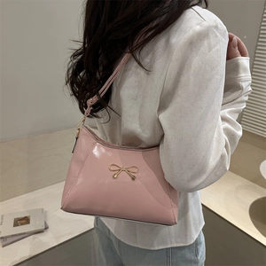 Elegante borsa a spalla in pelle verniciata rosa chiaro con fiocco dorato