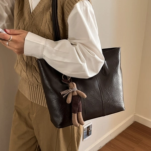 Retro deep brown tote bag with smooth leather texture and a cute bunny charm
