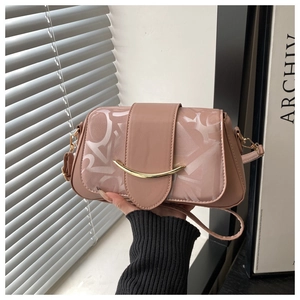 Gros plan d'un sac à main rose avec fermoir doré et motifs de lettres blanches