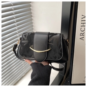 Détail d'un sac bandoulière noir avec fermoir doré et texture à motifs géométriques