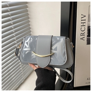 Détail du sac bandoulière en cuir gris avec boucle dorée et texture de rabat brillante