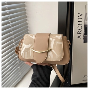 Détail d'un sac bandoulière beige minimaliste avec empiècement textile et métal doré