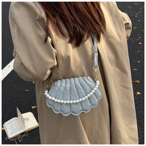 Detail of blue-grey shell-shaped shoulder bag with pearl chain and textured PU leather