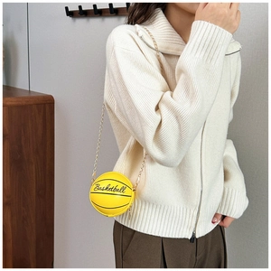 Détail d'un sac bandoulière créatif en forme de basket jaune avec chaîne dorée sur mannequin