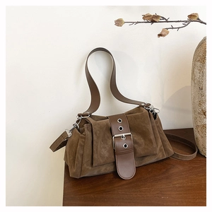 Détail du sac à main rétro en daim marron avec boucle métallique et bandoulière