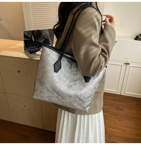 Détail du grand sac cabas argenté à texture tressée avec bandoulière noire chic