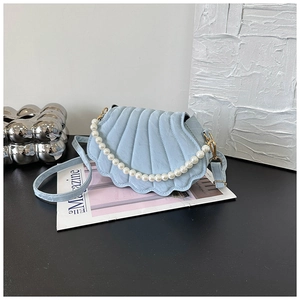 Detail of light blue shell bag with vertical pleated texture and white pearl handle