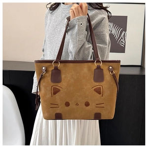 Close-up of suede kitty tote bag with cat face embroidery and brown leather straps