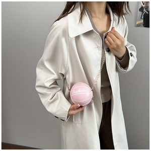 Mini sac basket rose avec chaîne dorée porté sur un trench-coat blanc élégant