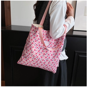 Detail showing pink seersucker floral tote bag with soft texture and brand label