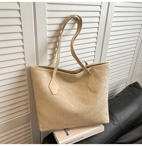 Detail of beige tote bag with textured faux leather on a black sofa by shutters
