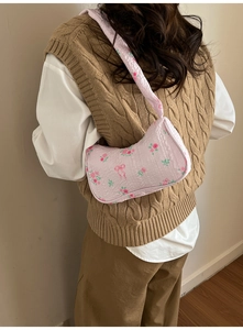 Vue détaillée du sac à bandoulière rose fleuri avec tissu texturé et motifs nœuds