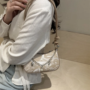 Elegante borsa sottobraccio beige con motivo bianco e ciondoli alla moda