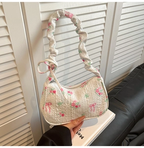 Détail du sac floral avec roses roses, nœuds rouges et texture de tissu plissé doux