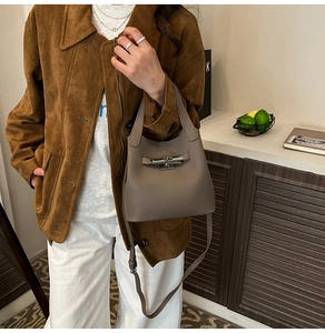 Détail du sac seau en cuir grainé avec boucle en métal et bandoulière amovible