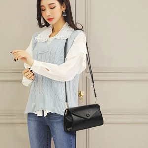 Chic sac à bandoulière en cuir noir brillant porté par mannequin en tenue décontractée