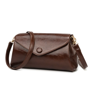 Sac à bandoulière marron brillant avec rabat rectangulaire et ferrures dorées sur fond blanc