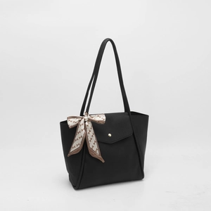 Detail of black pebbled leather tote with H-pattern silk scarf and gold button closure