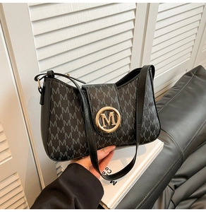 Details der Vintage-Umhängetasche mit goldenem M-Logo-Verschluss und Monogramm