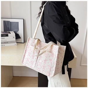 Detail of corduroy tote bag with pink bow prints and reinforced shoulder straps