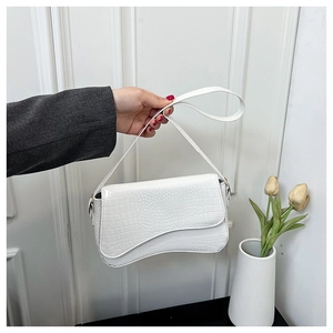 Close-up of white crocodile pattern shoulder bag featuring a unique wavy flap design