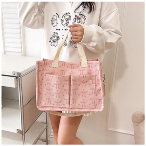 Detail of pink corduroy tote bag with bow prints and functional front pockets